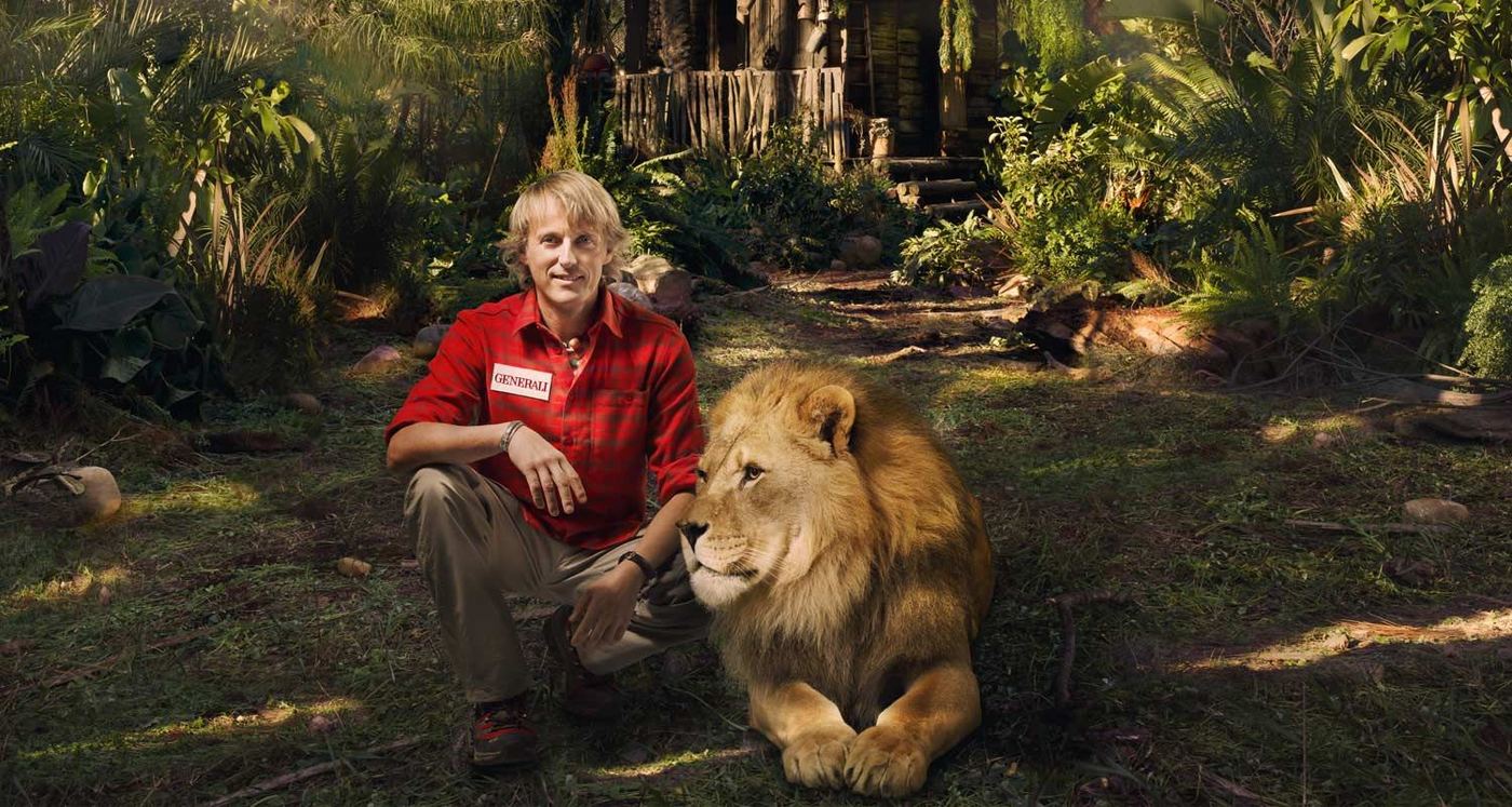 Jesús Calleja agachado junto a un león en un bosque